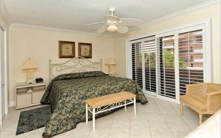 furnished bedroom with green bedding and ceiling fan at sea shell condominium sarasota