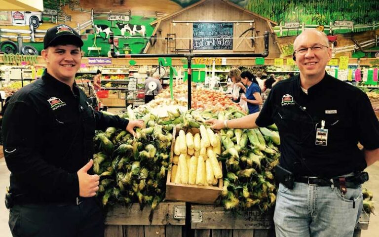 grocery store staff with corn cobs in produce store at detwilers farm market sarasota