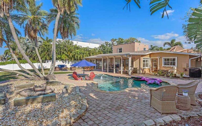 pool area behind house with palms at skyrun sarasota vacation rentals