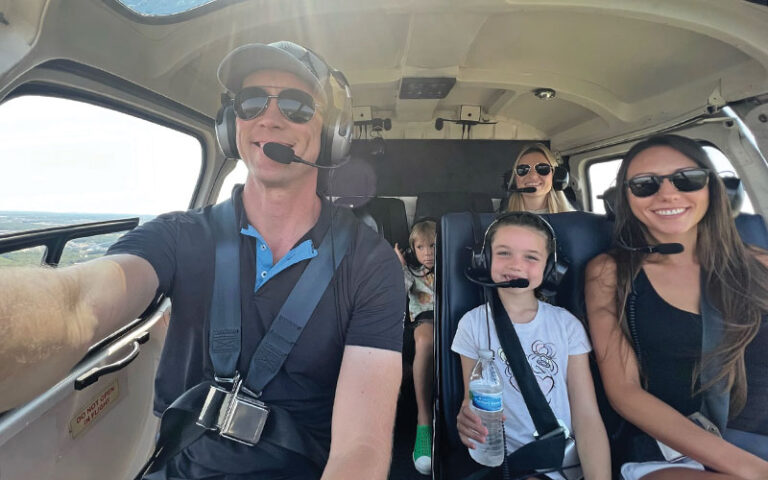 selfie with pilot and family smiling in cockpit at apex air helcopter tours kissimmee