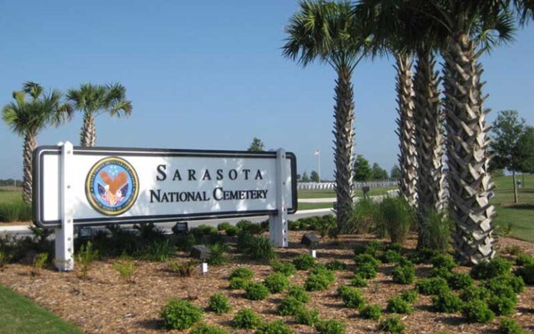 sign with military emblem under palm trees at sarasota national cemetery