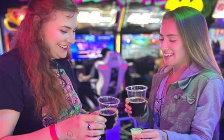 two ladies doing chaser shots in brightly colored bar at arcade monsters lido beach sarasota