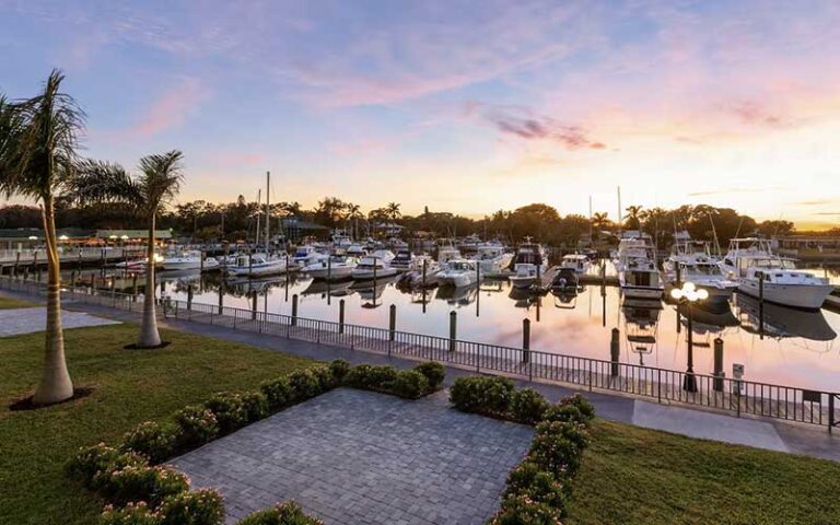 view of marina with boats and sunset at ramada by wyndham sarasota waterfront