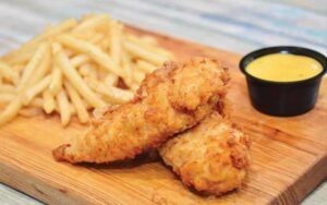 chicken tenders with sauce and fries on board at ghosted u orlando