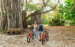 couple with bikes near banyan tree at hugh taylor birch state park fort lauderdale