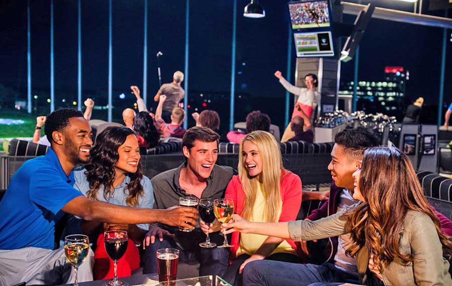 adult group toasting drinks at topgolf jacksonville