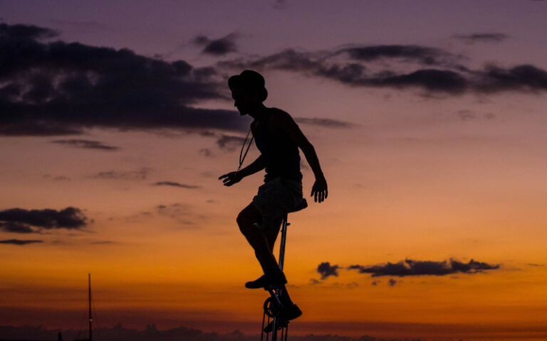 silhouette of street performer on unicycle with sunset background mallory square key west