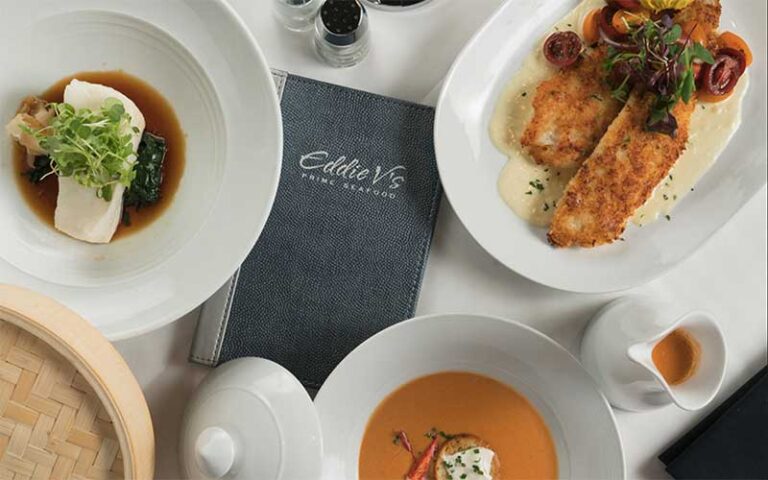 various entrees with menu on table at eddie v prime seafood ft lauderdale