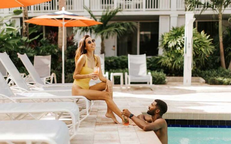 couple at pool area with drinks at opal key resort marina key west