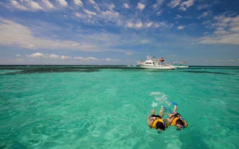 couple snorkeling with yacht in clear water inlet at john pennekamp coral reef state park key largo