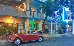 exterior of colonial style house with red vw bug at blue heaven key west