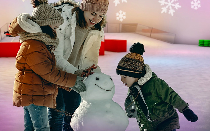 family making snowman in igloo structure building with snow at snowcat ridge dade city