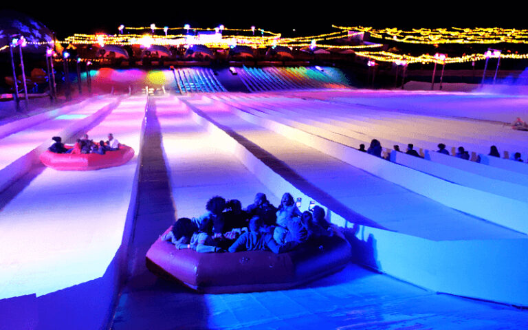 lighted tubing slope at night with group riding at snowcat ridge dade city