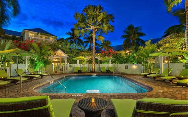 night view of pool with palms and green chairs at southernmost beach resort key west