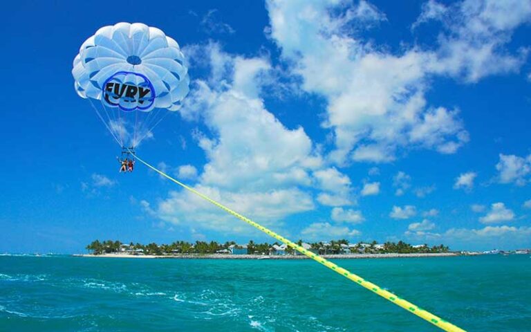 parasailing with fury logo over ocean with island at key west historic seaport