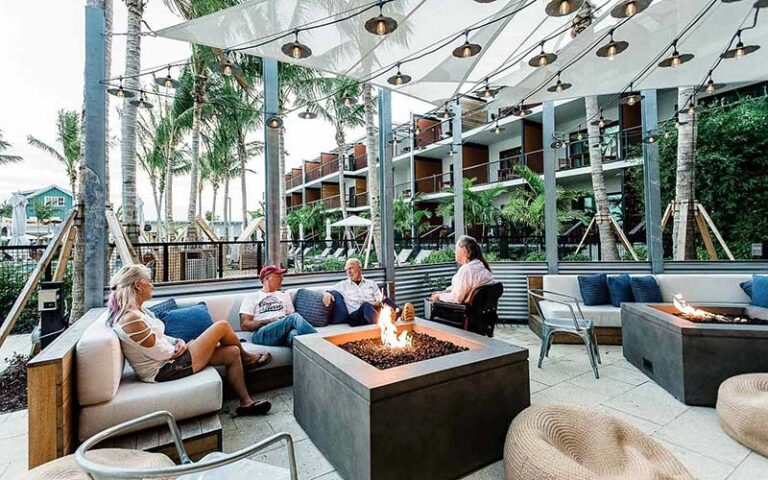 patio area overlooking marina with people chatting by fire at the perry hotel marina key west