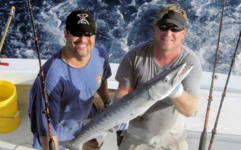 two fishermen holding a long fish on a boat at historic charter boat row key west