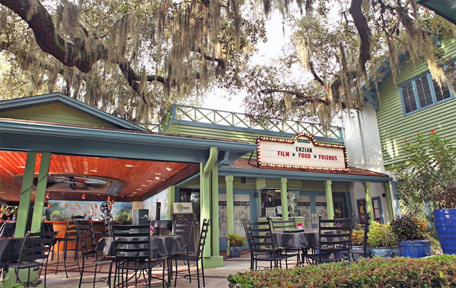 arthouse theater with marquee sign and patio bar under oak trees enzian orlando