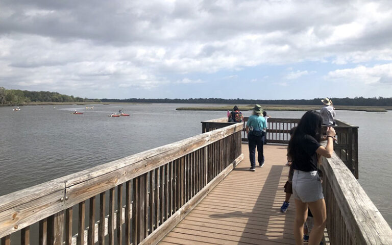 boardwalk dock group watching kayakers on waterway at betz tiger point preserve jacksonvile