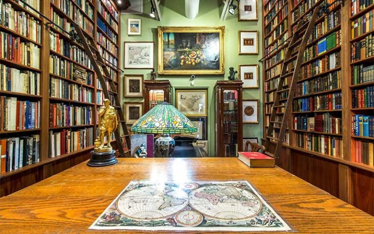 book shelves with map paintings and statue at old florida book shop fort lauderdale