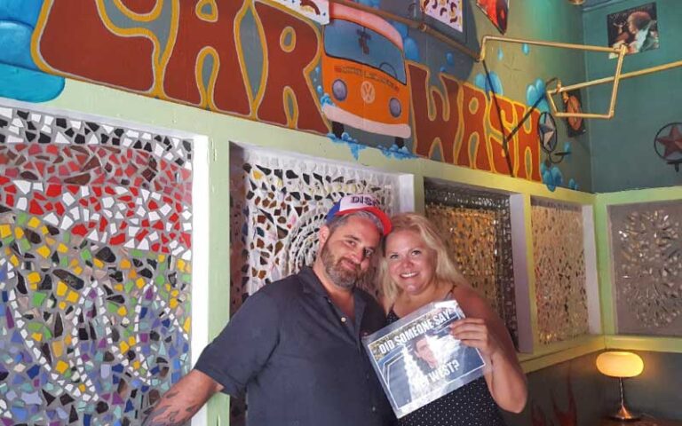 couple posing under car wash mural at key west room escape