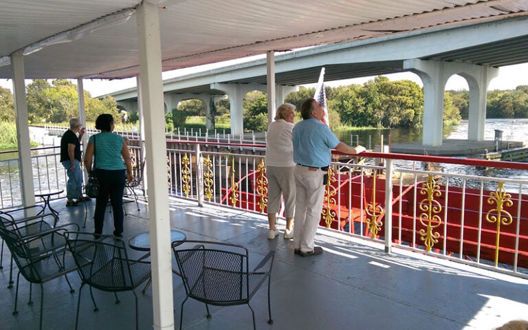 couples on boat viewing shore and bridge at st johns rivership co sanford