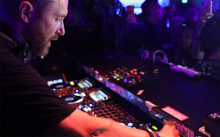 deejay working at nightclub with dance floor below at basement bowl and skate miami beach edition