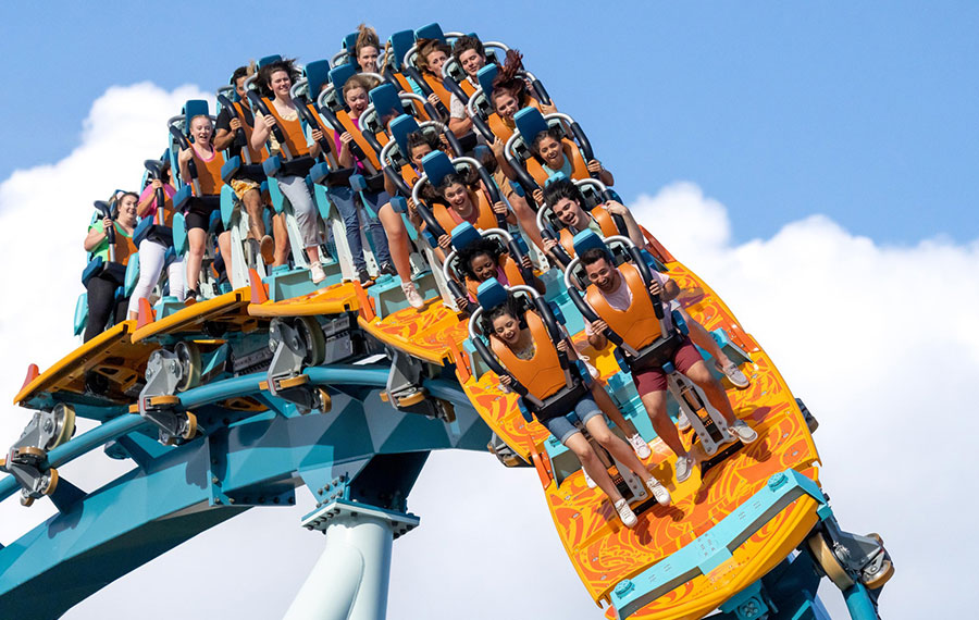 excited riders on surf style roller coaster twisting along track pipeline seaworld orlando