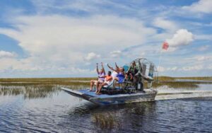 excited riders speeding in airboat at sawgrass recreation park everglades