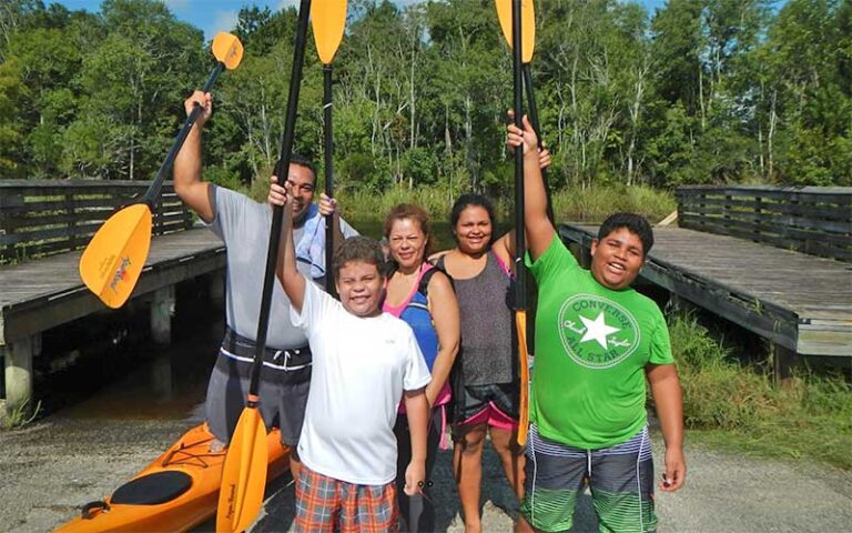 family of five cheering with kayak oars at adventures up the creek jacksonville
