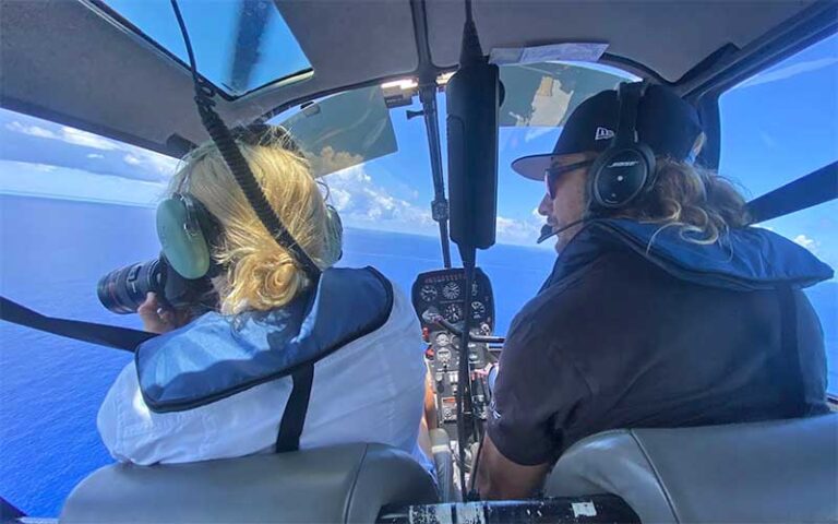 man and woman with camera in helicopter cockpit viewing ocean at keen fly fort lauderdale