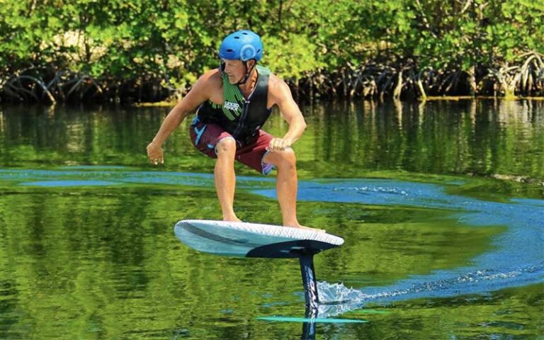 man on foilboard with green water and foliage at keys cable park marathon