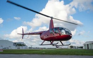 red helicopter taking off from runway at keen fly fort lauderdale