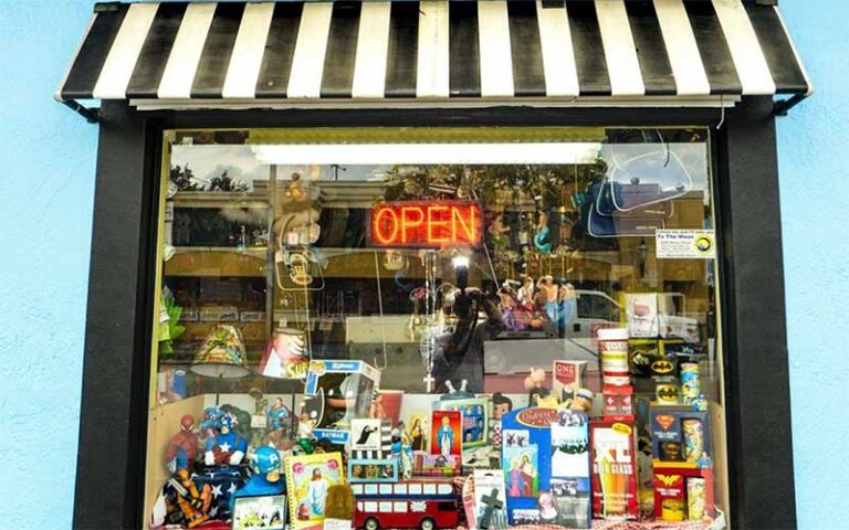 shop window with open sign and striped awning at to the moon marketplace ft lauderdale