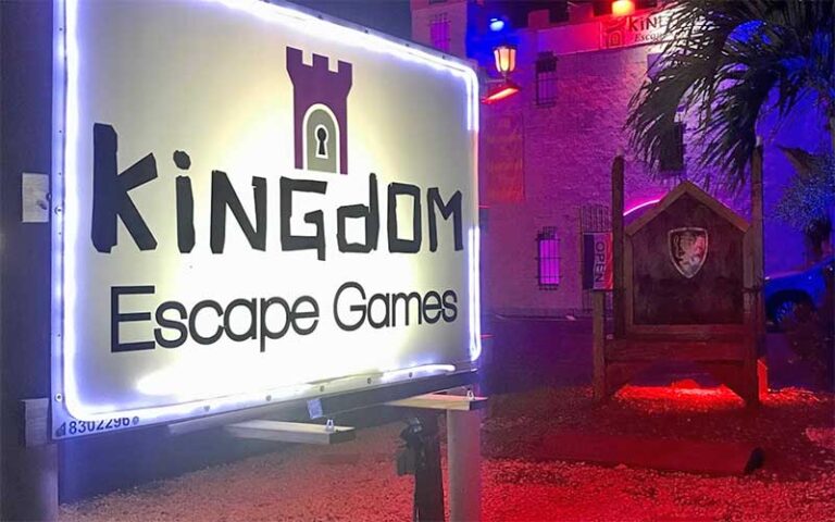 sign with castle themed building at night at kingdom escape games key largo