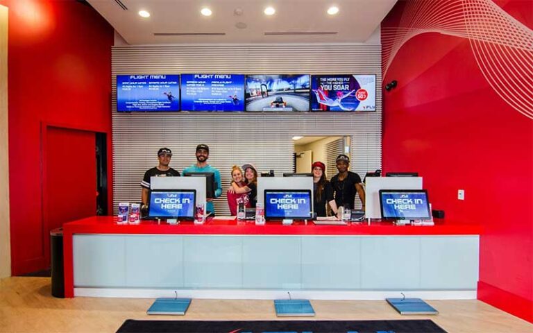 team members behind desk with photo packages on screens at ifly fort lauderdale