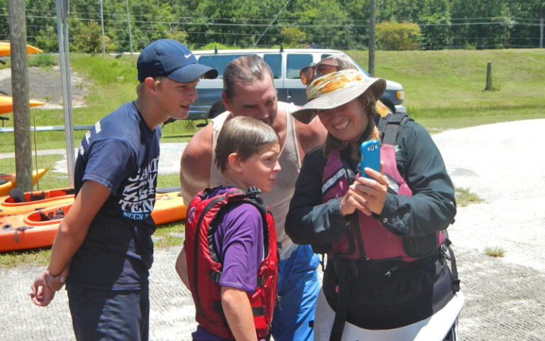 tour group admiring photos after kayaking trip at adventures up the creek jacksonville