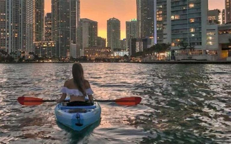 young lady kayaking on bay at night with skyline at sunrise paddleboards fort lauderdale