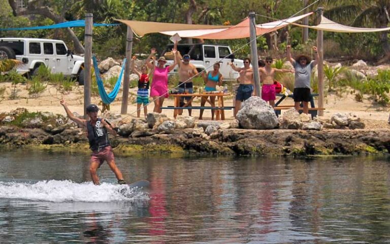 young man wakeboarding past cheering friends in waterside pavilions at keys cable park marathon