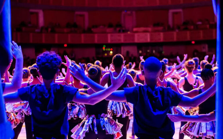 young performers onstage with purple lighting and curtains at adrienne arsht center for the performing arts miami