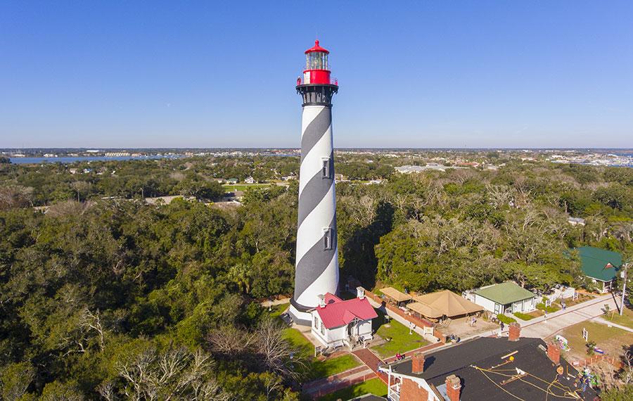 aerial view of black and white lighthouse with red top and trees st augustine lighthouse maritime museum