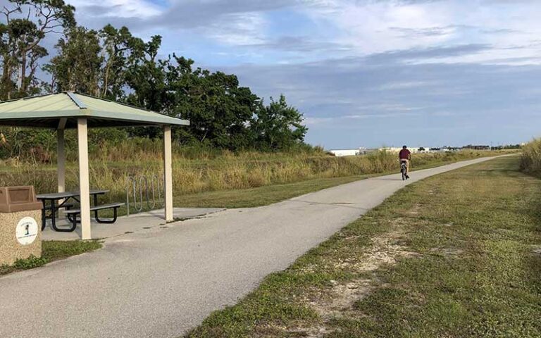 biker on trail with pavilion and picnic table at john yarbrough linear park fort myers