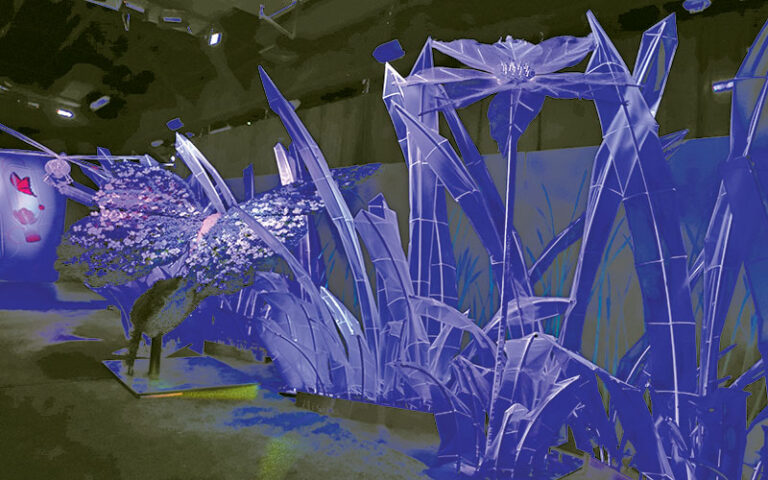 blue sculptures of flowers and butterfly in black light set at earth illuminated orlando
