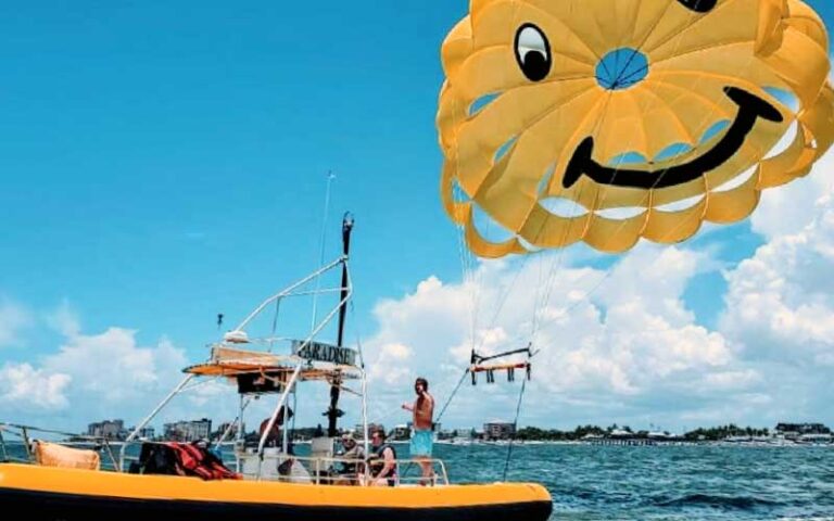 boat with yellow happy face parachute at paradise parasail fort myers beach