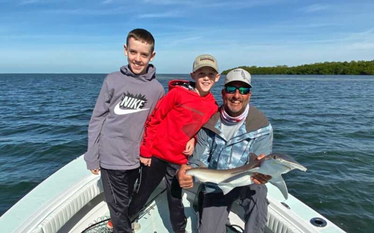 boy and dad holding small shark they caught at salty native charters fort myers