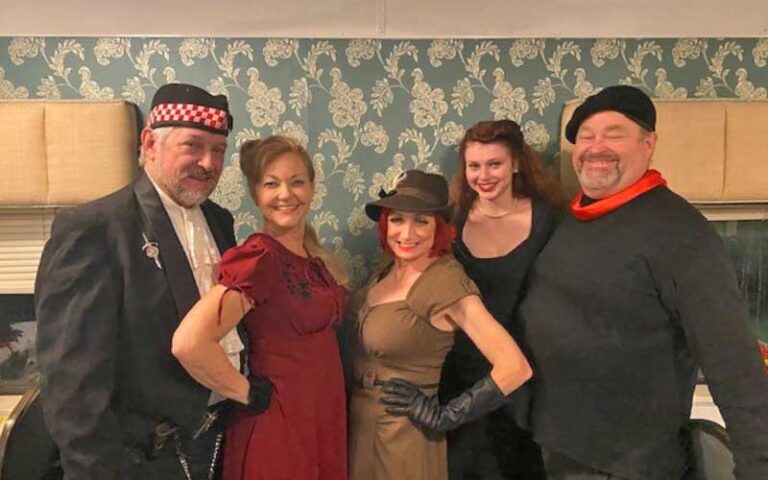 cast of characters posing on train at murder mystery dinner train fort myers