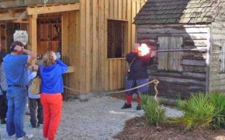 costumed man firing musket with onlookers holding their ears at colonial quarter st augustine