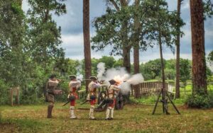 costumed reenactment with row of men shooting muskets in woods at fort mose state park st augustine