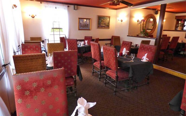 cozy dining area with red chairs and carpet at old city house inn restaurant st augustine
