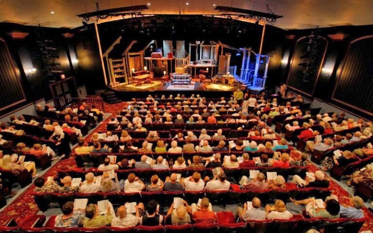 crowded seats of theater with empty living room setting on stage at florida repertory theatre fort myers